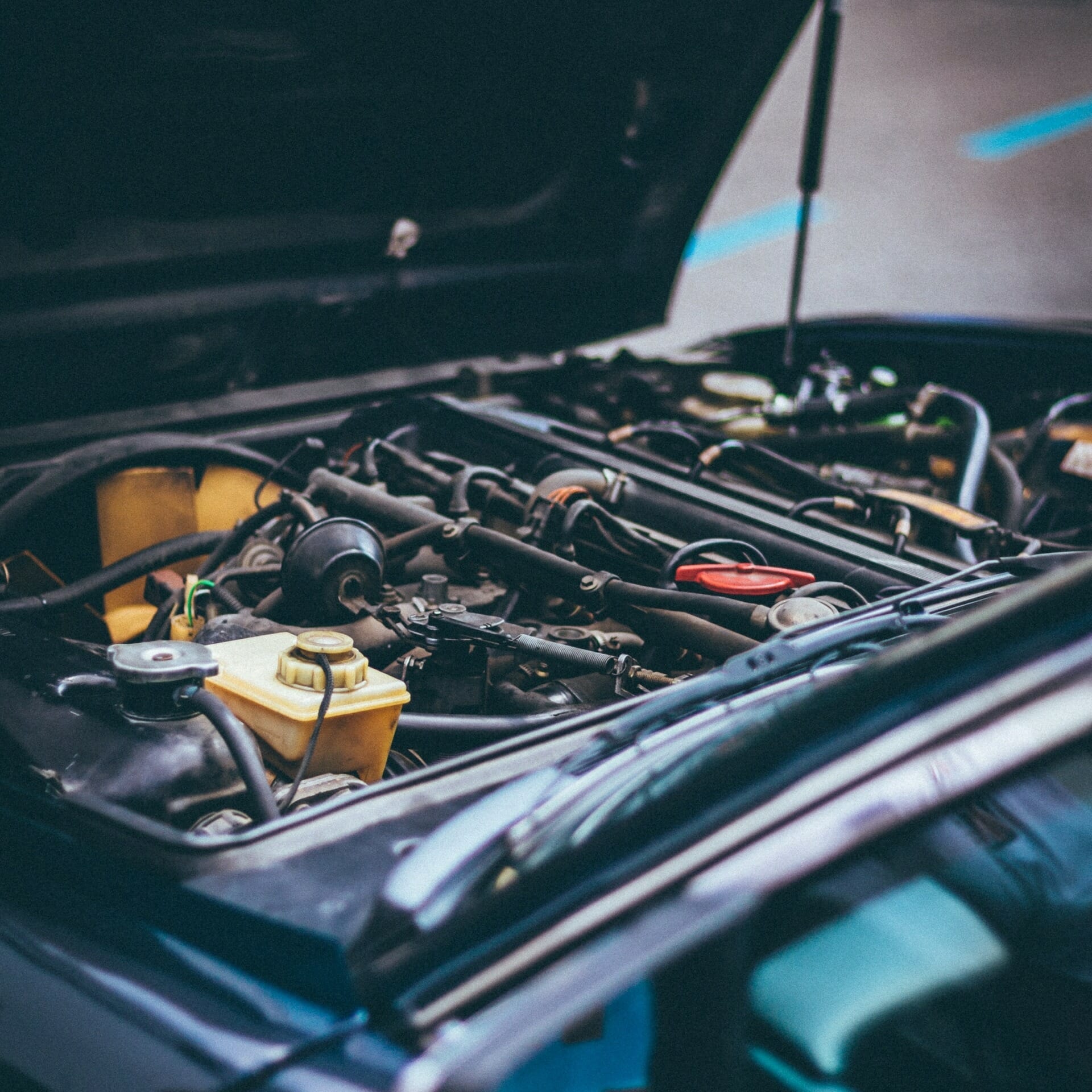 An open car hood revealing the engine and various mechanical components inside, akin to peering into an ERP system showcasing its intricate modules and processes.