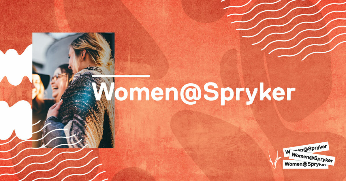 Women laughing together beside the text "Women@Spryker" on a red-orange background with abstract wavy lines, celebrating moments from the HERd Conference.