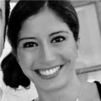 A woman smiling in a black-and-white photo. She has dark hair pulled back and is facing the camera, embodying the timeless elegance even as digital commerce shapes new AI trends.