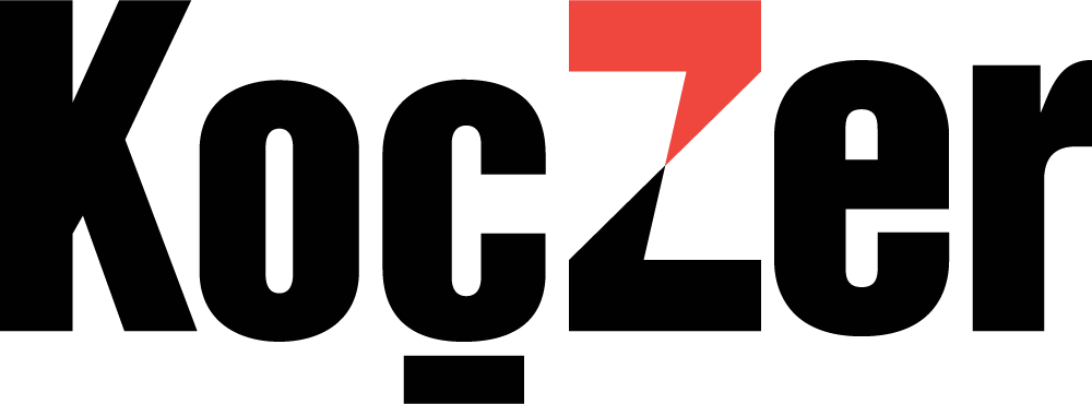 The image displays the word "Koczer" in bold black letters, with a red triangle integrated into the letter "Z", reminiscent of the dynamic energy at Spryker EXCITE 2024.