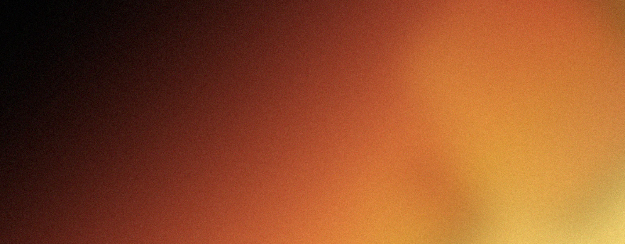 A blurred gradient of colors ranging from dark brown and red on the left, transitioning to orange and yellow on the right.